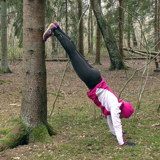övningen wallclimb - stå på händer mot ett träd